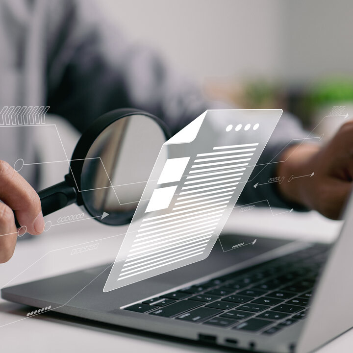 man inspecting paperwork with magnifying glass